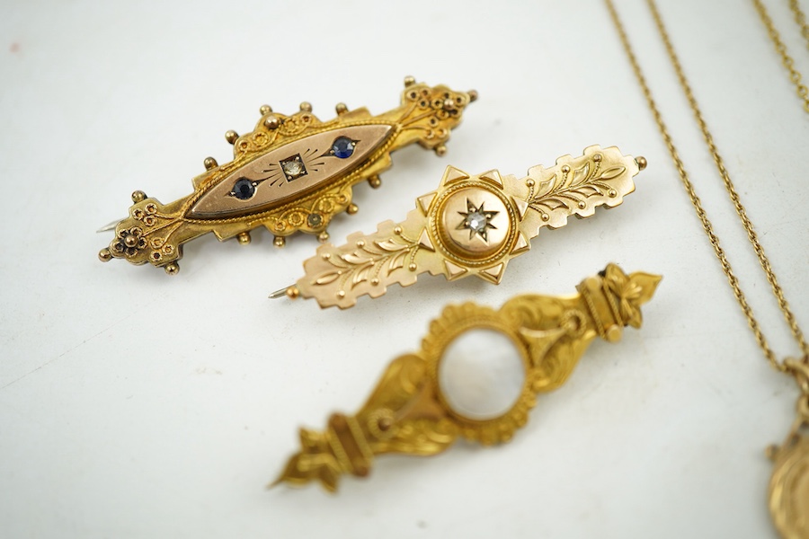 A collection of jewels, comprising: two cross pendants; a heart-shaped locket pendant; a circular locket pendant engraved with a sunflower; a pendant set with a sapphire; a diamond panel brooch; and a sapphire and diamon